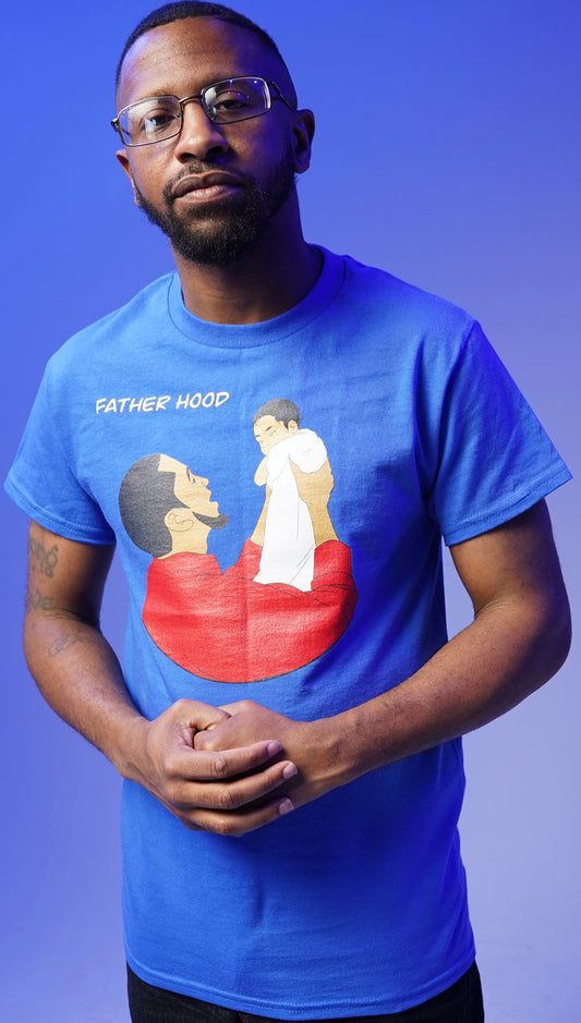 EDGE wearing a blue T-shirt with a graphic design and the text 'FATHERHOOD' on it.